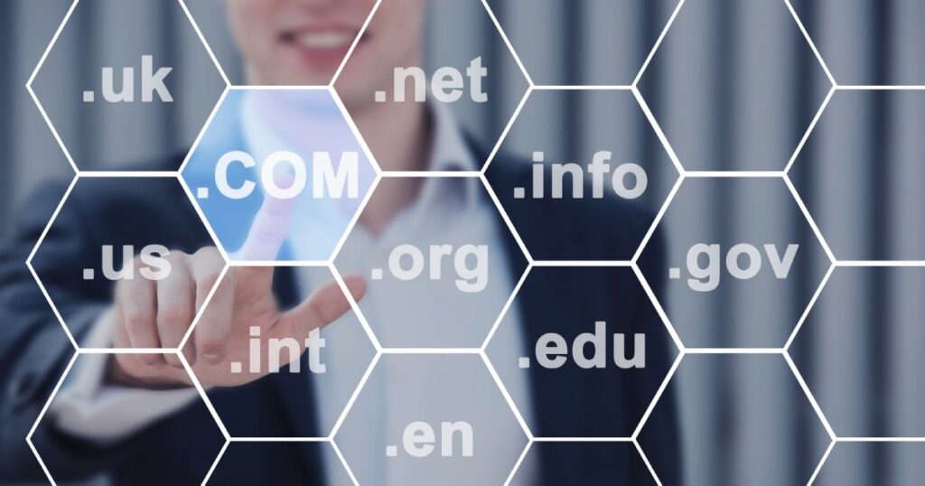 Tecla preta com o texto “.com” a flutuar sobre fundo cinza suave, simbolizando presença digital, identidade online e propriedade virtual.