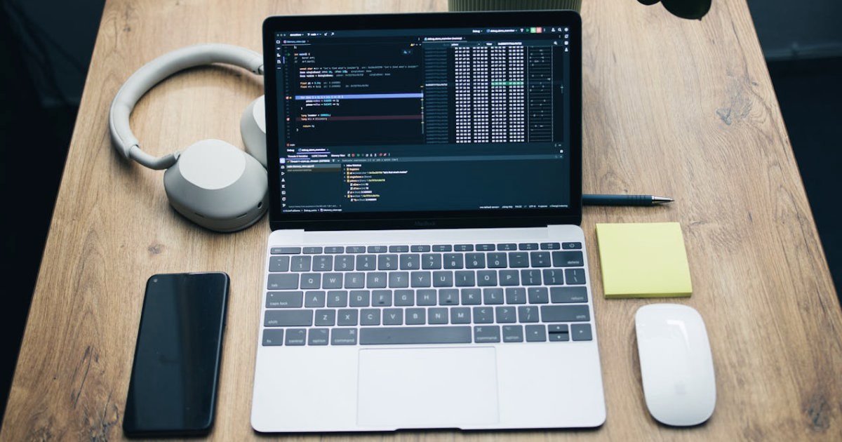 Posto trabalho, notebook, smartphone, fones e rato.